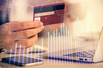 Multi exposure of woman on-line shopping holding a credit card and financial graph drawing. Stock market E-commerce concept.