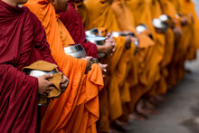 MONKS DOING ALMS, BATTAMBANG, CAMBODIA - 17 December 2014: Long Line Of Begging Bowls Expecting Donations Of Rice In Support Of Monks Spiritual Quest.