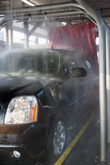 Spraying water on automobile in car wash