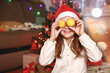 Funny girl in a Christmas costume holding tangerines.