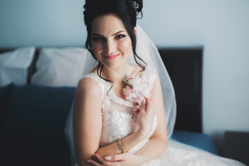 Portrait of beautiful bride with fashion veil at wedding morning