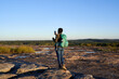 © Mhandy/Creative Flame - Black woman takes picture of beautiful mountain top view at sunset