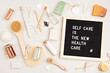 © netrun78 - Self care is the new health care. Motivational quote on black letter board with variety of organic body and face care products. Natural homemade eco friendly beauty products