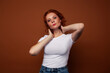 © iordani - young pretty redhead girl posing cheerful on warm brown background, lifestyle people concept