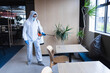 © Wavebreak Media - Health worker in protective clothing spraying disinfectant in office