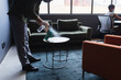 © Wavebreak Media - Midsection of mixed race man wearing face mask disinfecting table in office
