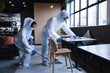 © Wavebreak Media - Health workers in protective clothing disinfecting creative office
