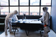 © Wavebreak Media - Health workers in protective clothing disinfecting creative office