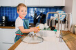 a boy helps his parents wash dishes.