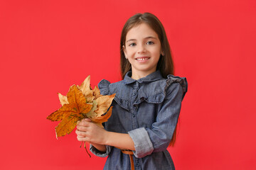 Canvas Print - Cute little girl with autumn leaves on color background