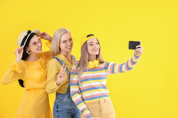 Canvas Print - Beautiful young women taking selfie on color background