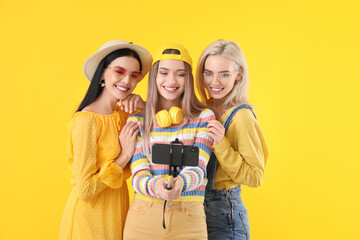 Wall Mural - Beautiful young women taking selfie on color background