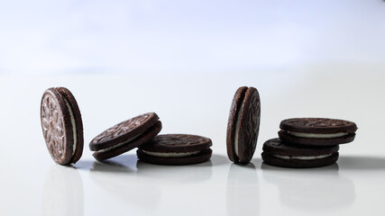 Wall Mural - Chocolate sandwich cookies with vanilla cream filling on white large bakground.