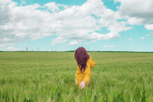 Beautiful Girl With Bright Red Hair Is Happy In A Wheat Field. Blue Sky With Small Cloudless Clouds, Agriculture And Village Concept