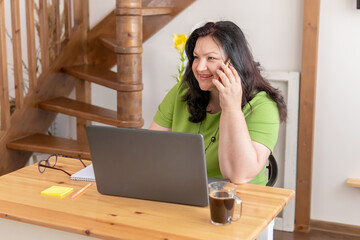 Wall Mural - Cute woman in the office sitting at a Desk with a laptop