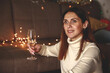 Portrait of a beautiful young woman holding a glass of champagne in her hands.