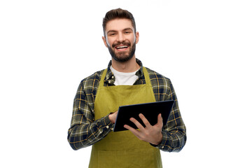 gardening, farming and technology concept - happy smiling male gardener or farmer in apron and rubber boots with tablet pc computer over white background
