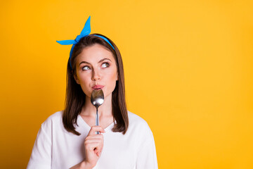 Photo of charming girl lick spoon look u empty space wear blue headband white t-shirt isolated yellow color background