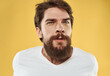 © SHOTPRIME STUDIO - Handsome man in a white t-shirt on a yellow background emotions model stress