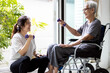 © Satjawat - Asian caregiver is doing physical therapy for the old elderly,disabled senior woman in a wheelchair,exercise use dumbbells to help strengthen the muscles of hands,arms and shoulders,workout at home