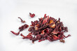 Hibiscus tea dried flowers heap on white background. Vitamin, recipe, beverage concept. Close-up, copy space