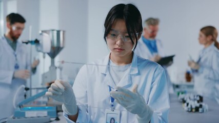 Female asian scientist using professional pc tablet innovative computer mock-up touchscreen hologram app while working at medical laboratory science center.