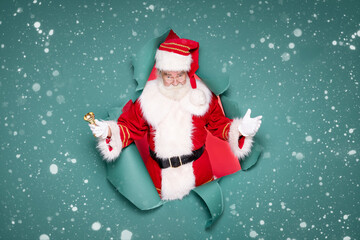 Photo of traditional Santa Claus ringing on a gold bell.