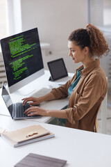 Wall Mural - young woman sitting at the table and concentrating on online work on laptop working at computer serv