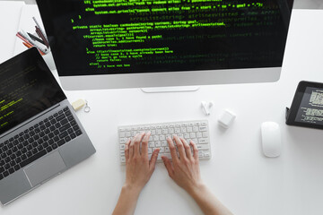 Wall Mural - high angle view of developer typing on computer keyboard installing the new system on computer at th