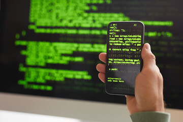 Wall Mural - close-up of developer writing programming code on mobile phone and computer