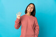 Young latin woman isolated on blue background happy and counting four with fingers