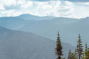 Wall Mural - Scenic view of misty mountain valley. Gentle hills under overcast clouds.