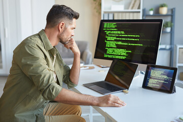 Wall Mural - mature computer technician concentrating on his work looking at computer monitor while installing so
