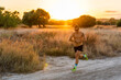 © Javier De La Torre/ADDICTIVE STOCK - Active male athlete with strong body running along rural road and checking time on wristwatch during intense training in summer