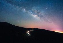 Amazing Scenery Of Illuminated Road With Traffic Lights In Dark Highlands Under Spectacular Sky With Stars In Tenerife