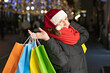 © Наталья Жукова - girl with colored bags in her hands on the street. Christmas holiday