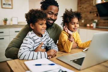 Wall Mural - Happy black father and children having video call over laptop at home.