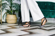 © Victor Gonzalez/ADDICTIVE STOCK - Side view of anonymous crop female wearing wedge sandals and trendy jeans standing in modern flat