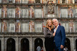 © Si And Si/ADDICTIVE STOCK - Elegant well dressed middle aged couple in stylish clothes smiling happily while embracing each other against blurred building on city street looking at camera