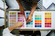 © Victor Gonzalez/ADDICTIVE STOCK - Top view of unrecognizable female designers standing at table in bright studio and choosing color of textile samples