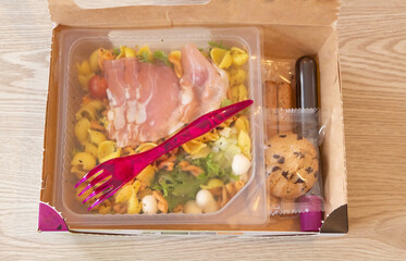 Wall Mural - Industrial mixed salad, breadstick, dressing and cookie in a cardboard box