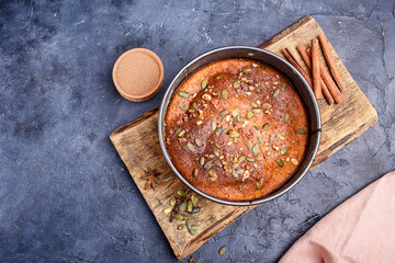 Pumpkin pie with lemon zest, pumpkin seeds, cinnamon, fragrant spices and spices on a dark background.