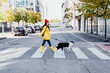 © VISTA by Westend61 - Woman walking with dog on pedestrian crossing during sunny day
