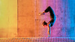 © VISTA by Westend61 - Woman practicing gymnastic in multi colored light against wall