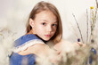 © Irina Ozhigova/Stocksy - Portrait of a girl in blue dress sitting among dry twigs