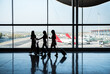 © David Prado/Stocksy - Anonymous women walking near airport window