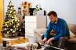 © David Prado/Stocksy - Bearded man using laptop at home