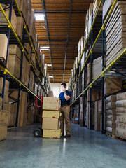 Caucasian worker using laptop in warehouse
