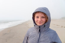 Portrait Of Smiling Caucasian Girl On Cold Beach