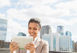 © JGI/Jamie Grill/Blend Images - Asian businesswoman using digital tablet on urban balcony
